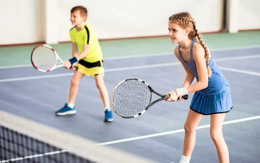 a woman and a boy playing tennis