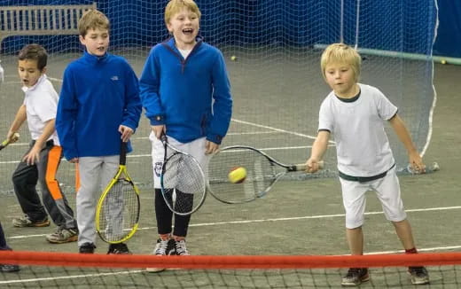 a group of kids holding tennis rackets