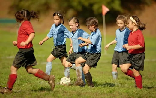 a group of girls compete over a football ball