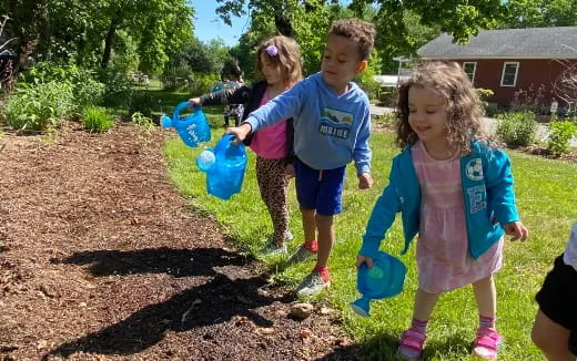 a group of children carrying blue buckets