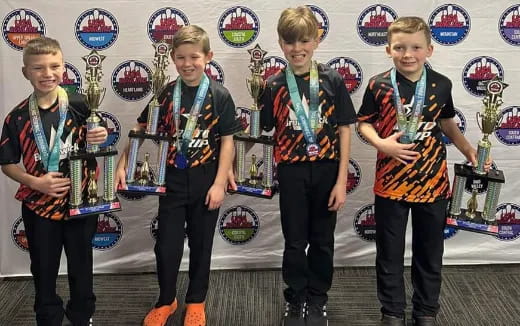 a group of boys holding trophies