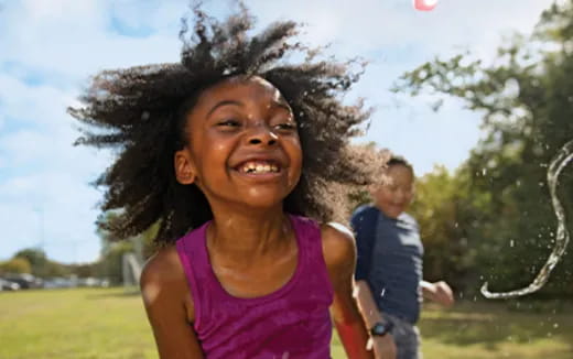 a girl smiling with a boy behind her