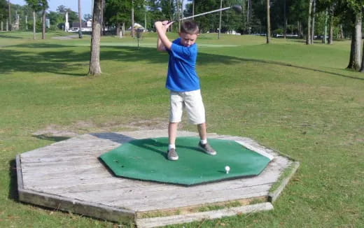 a boy swinging a golf club