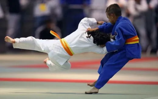 a man kicking another man in the face with a sword