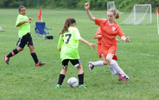 girls playing football on a field
