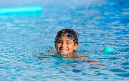 a boy swimming in a pool