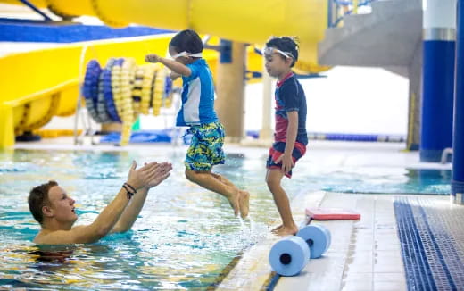 a group of kids playing in a pool