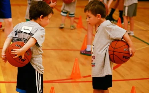 a couple of boys holding basketballs