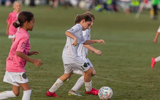 girls playing football on a field