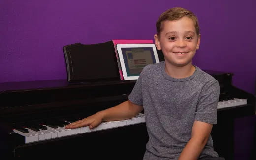 a boy sitting at a piano