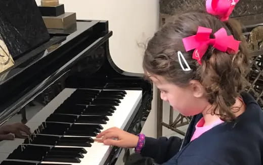 a couple of girls playing piano