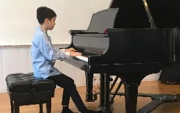 a boy playing a piano