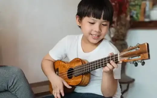 a young boy playing a guitar