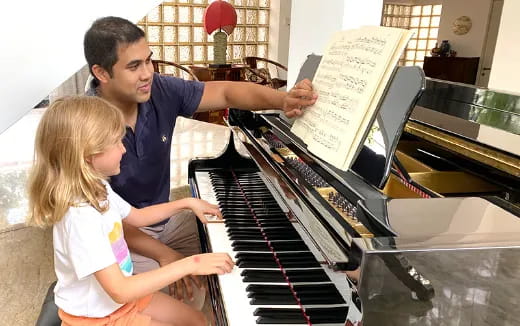 a person and a girl playing piano