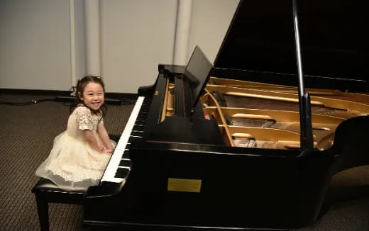 a girl sitting at a piano
