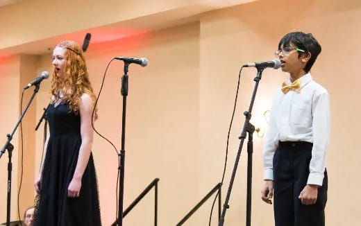 a man and woman standing in front of microphones