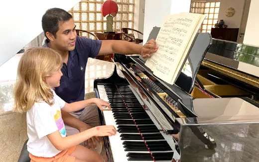 a person and a girl playing piano
