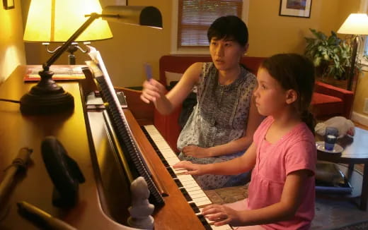 a boy and girl playing piano
