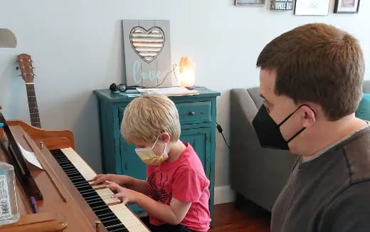 a person and a child playing piano