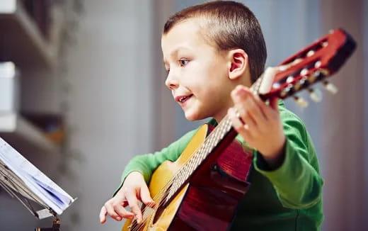 a young boy playing a guitar