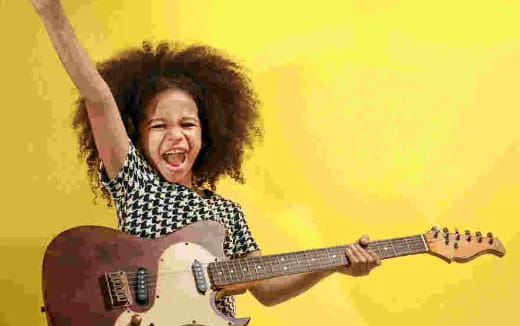 a young boy playing a guitar