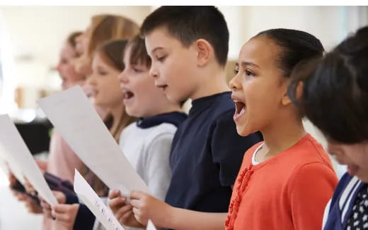 a group of children looking at a paper