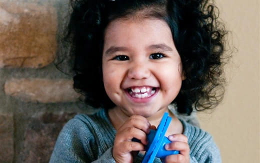 a girl holding a blue toothbrush