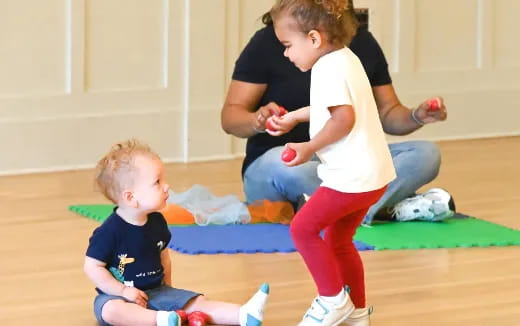 a person and a child playing with a ball on the floor