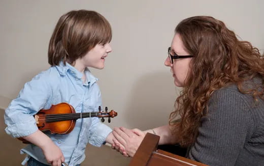 a person and a child playing violin