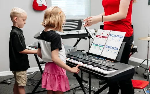 a couple of kids playing a piano