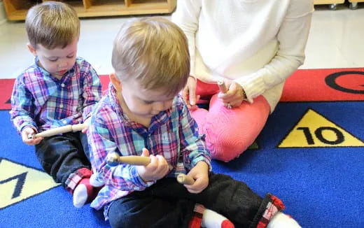 a person and two boys sitting on the floor