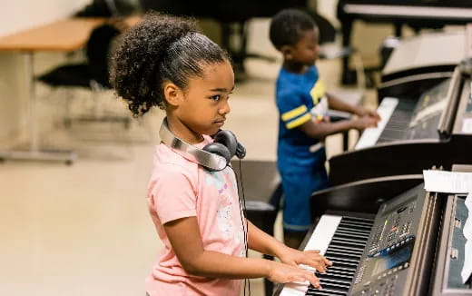 a young girl playing a piano