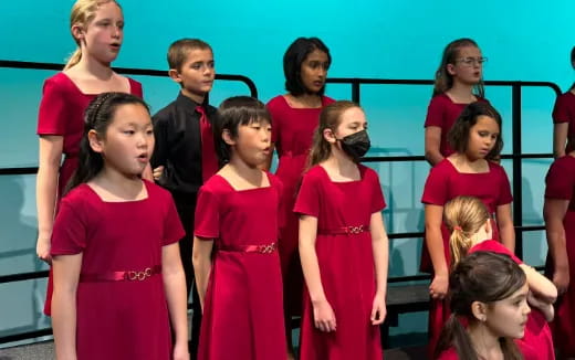 a group of children in red dresses