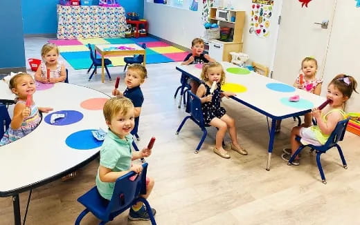 a group of children sitting around a table