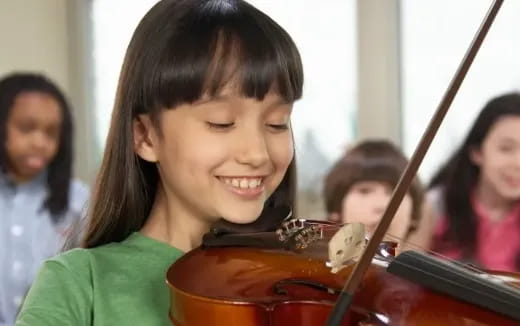 a young girl playing a violin
