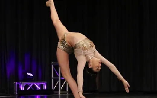 a woman doing a handstand on a stage