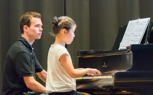 a man and a woman playing piano