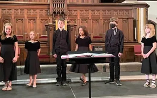 a group of people standing around a piano
