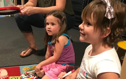 a person and a girl sitting on the floor
