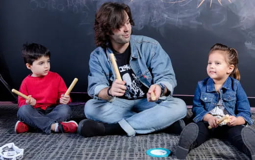 a person and two boys sitting on the floor