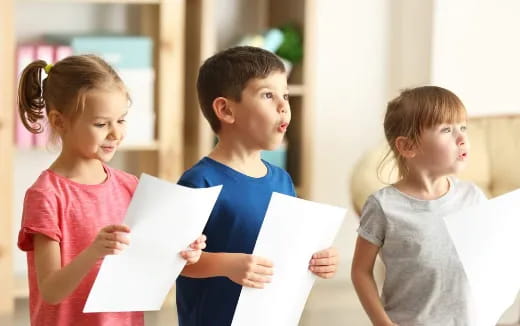a group of children holding papers