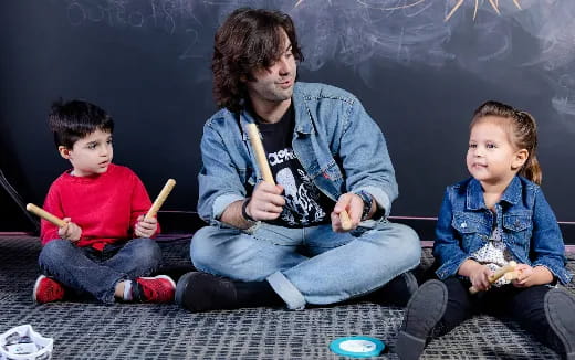 a person and two children sitting on the floor