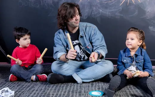 a person and two children sitting on the floor