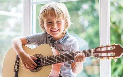 a young boy playing a guitar