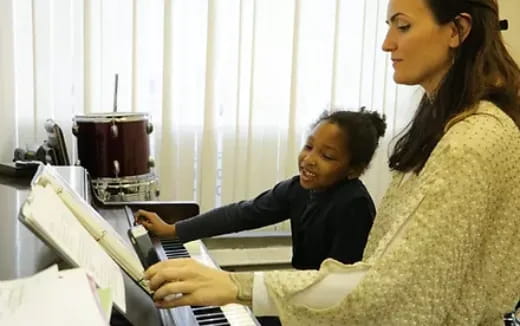 a woman showing a woman something on the computer