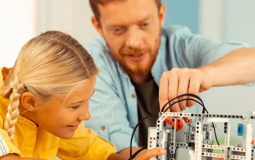 a person and a child looking at a computer