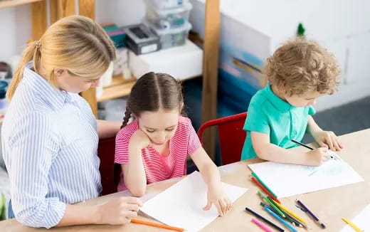 a person and a couple of children sitting at a table