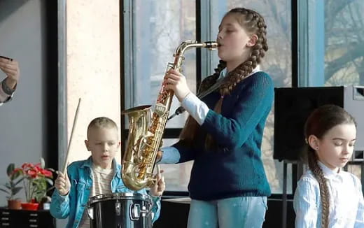 a person playing a saxophone with children