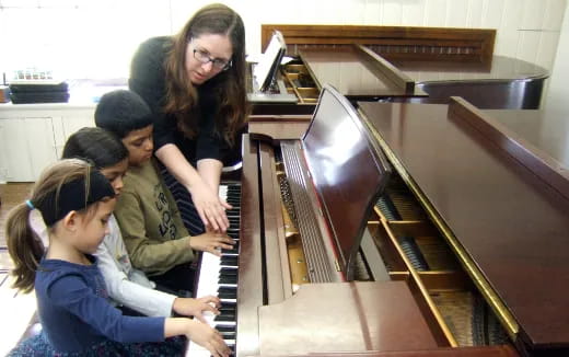 a group of children playing piano