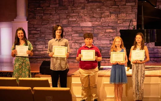 a group of people holding certificates